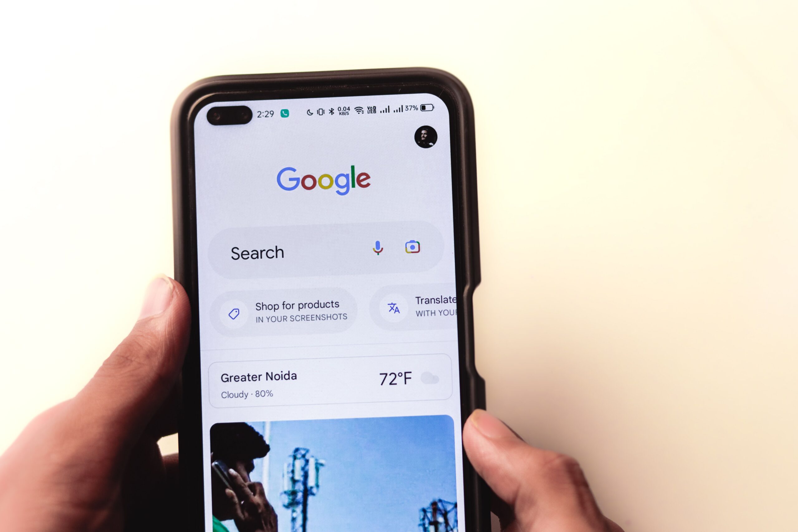 local seo tips, A close-up of a hand holding a smartphone with Google search displayed on the screen.